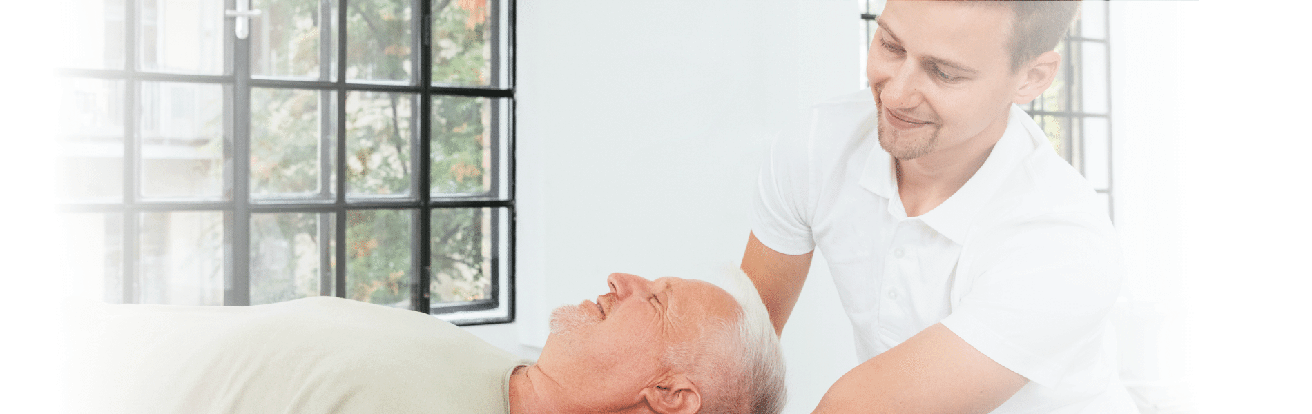 Ein Physiotherapeut von Bunz mobile Physio therapiert einen älteren Patienten